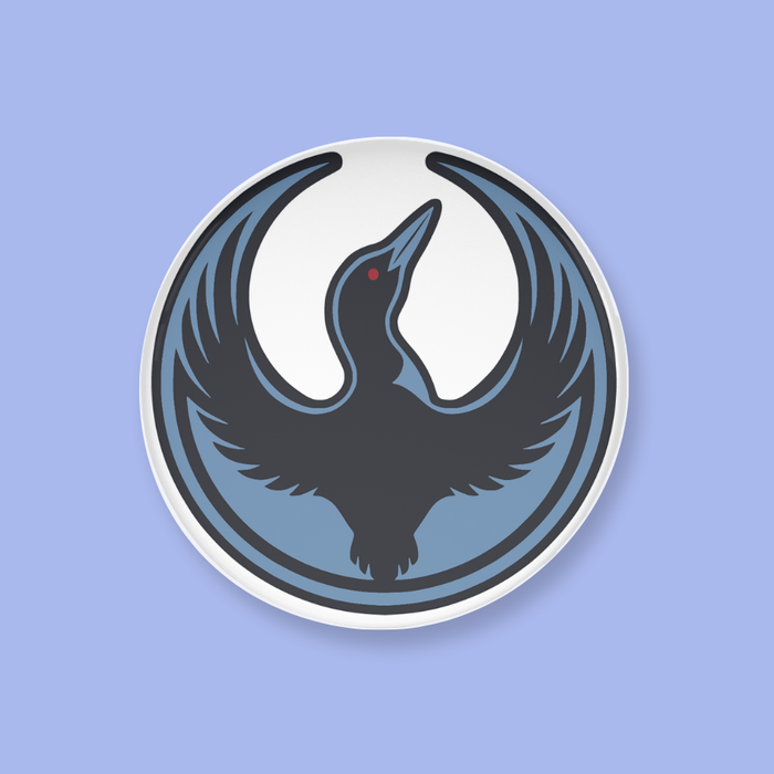 A button with a black loon design on a light blue background