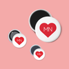 Set of three magnetic buttons with red hearts and 'MN' text on a pink background