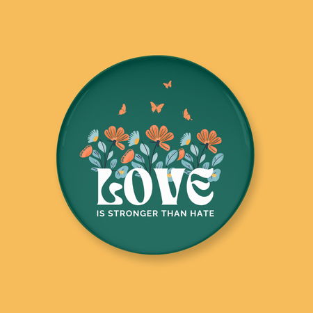 Button with floral design and 'Love is Stronger than Hate' text on a yellow background