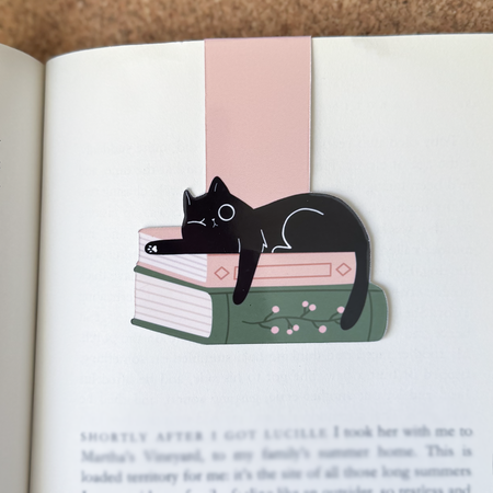 Cat-shaped bookmark on an open book